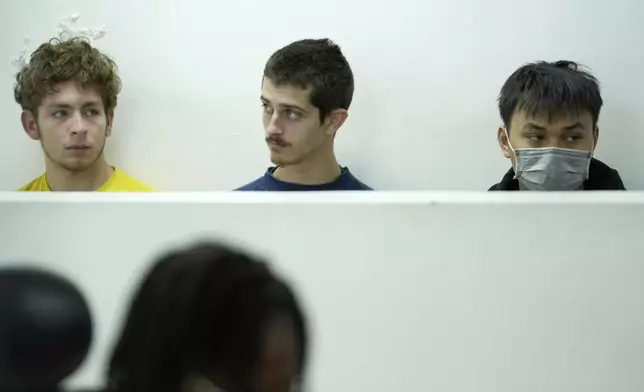Belgian nationals Lornoy David, left, Seppe Lodewijckx, center and Vietnamese national Duh Hung Nguyen appear at the Jomo Kenyatta International Airport Law Courts in Nairobi, Kenya Wednesday, April 23, 2025. (AP Photo/Brian Inganga)