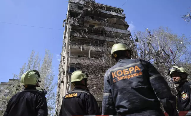 Rescue workers inspect a multi-storey building damaged by a Russian strike on residential neighbourhood in Zaporizhzhia, Ukraine, on Tuesday, April 22, 2025. (AP Photo/Kateryna Klochko)