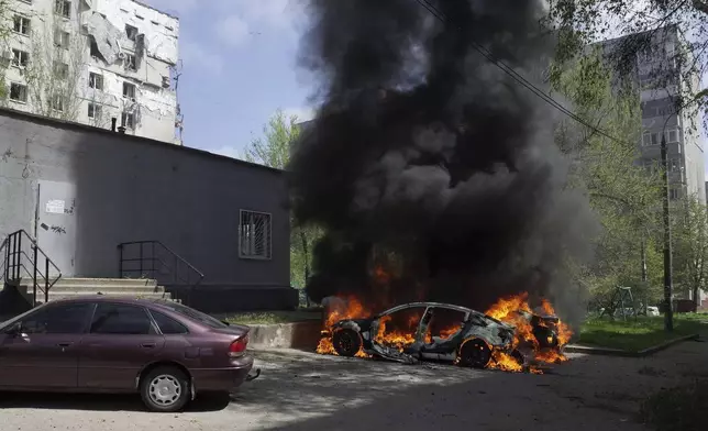A car burns near a residential building damaged by a Russian strike in Zaporizhzhia, Ukraine, Tuesday, April 22, 2025. (AP Photo/Andriy Andriyenko)