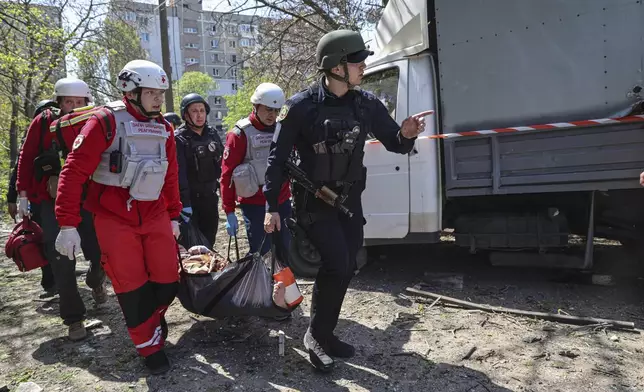 Paramedics carry an injured woman to an ambulance near a multi-storey building damaged by a Russian strike on residential neighbourhood in Zaporizhzhia, Ukraine, on Tuesday, April 22, 2025. (AP Photo/Kateryna Klochko)