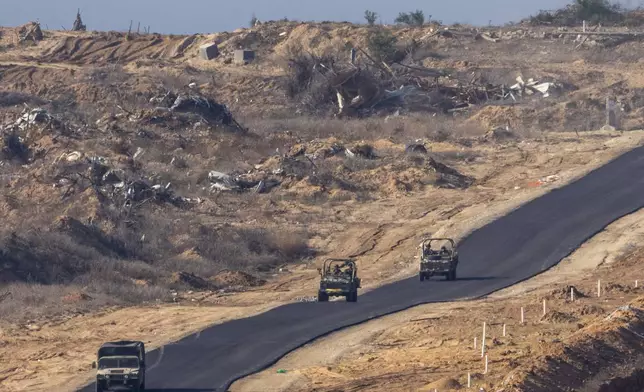 FILE - Israeli military vehicles move inside the Gaza Strip, as seen from southern Israel, Tuesday, Jan. 7, 2025. (AP Photo/Ariel Schalit, File)