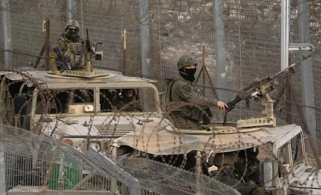 FILE - Israeli soldiers stand on armoured vehicles after crossing the security fence near the so-called Alpha Line that separates the Israeli-controlled Golan Heights from Syria, in the town of Majdal Shams, Dec. 21, 2024. (AP Photo/Matias Delacroix, File)