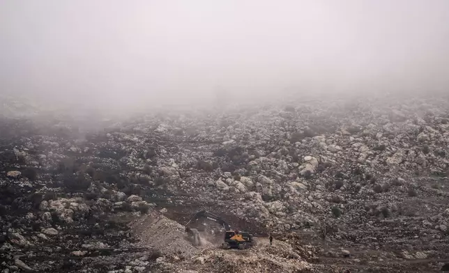 FILE - An Israeli bulldozer maneuvers on the buffer zone near the so-called Alpha Line that separates the Israeli-controlled Golan Heights from Syria, viewed from the town of Majdal Shams, Dec. 21, 2024. (AP Photo/Matias Delacroix, File)