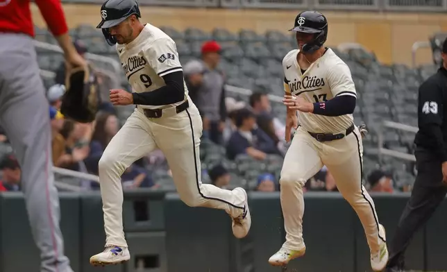Minnesota Twins' Trevor Larnach (9) and Ty France (13) score on a double by Ryan Jeffers against the Los Angeles Angels in the sixth inning of a baseball game Sunday, April 27, 2025, in Minneapolis. (AP Photo/Bruce Kluckhohn)