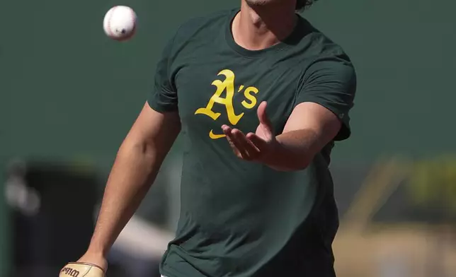 Athletics top prospect Nick Kurtz tosses a baseball during warmups of a baseball game against the Texas Rangers Tuesday, April 22, 2025, in West Sacramento, Calif. (AP Photo/Scott Marshall)