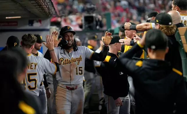 Pittsburgh Pirates outfielder Oneil Cruz (15) high fives teammates in the dugout after hitting a home run during the fifth inning of a baseball game against the Los Angeles Angels, Wednesday, April 23, 2025, in Anaheim, Calif. (AP Photo/Eric Thayer)