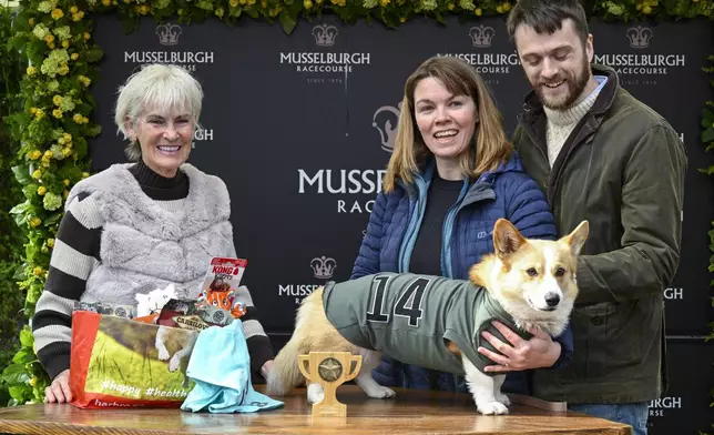 Winner of the Corgi Derby, Juno with his owners Fran Brandon and Alisdair Tew, is presented a trophy from Judy Murray at Musselburgh Racecourse, Musselburgh, Scotland, Saturday, April 19, 2025, as part of its Easter Saturday race day celebration. (Lesley Martin/PA via AP)
