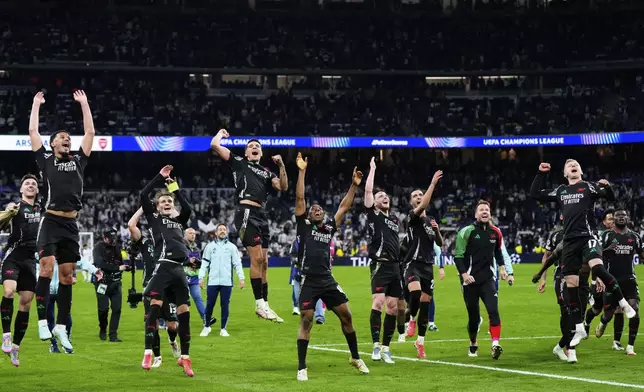 Arsenal players celebrate after defeating Real Madrid 2-1 in the Champions League quarterfinals second leg soccer match at the Santiago Bernabeu stadium in Madrid, Wednesday, April 16, 2025. (AP Photo/Manu Fernandez)