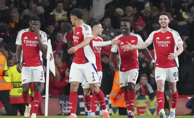 Arsenal's Declan Rice, right, celebrates with his teammates after scoring his side's opening goal during the Champions League quarterfinal first leg soccer match between Arsenal and Real Madrid at the Emirates Stadium in London, Tuesday, April 8, 2025. (AP Photo/Frank Augstein)