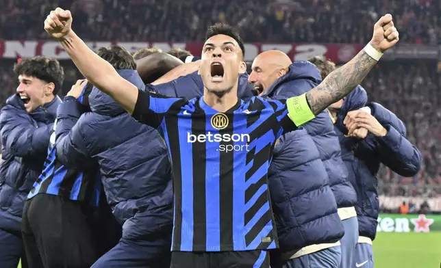 Inter's Lautaro Martinez, center, and Nicolo Barella, right, celebrate after the Champions League quarterfinals first leg soccer match between FC Bayern Munich and Inter Milan, at the Allianz Arena in Munich, Germany, Tuesday, April 8, 2025. (Peter Kneffel/dpa via AP)