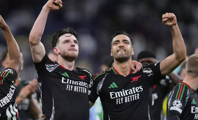 Arsenal's Declan Rice and Mikel Merino, right, celebrate after defeating Real Madrid 2-1 in the Champions League quarterfinals second leg soccer match at the Santiago Bernabeu stadium in Madrid, Wednesday, April 16, 2025. (AP Photo/Manu Fernandez)
