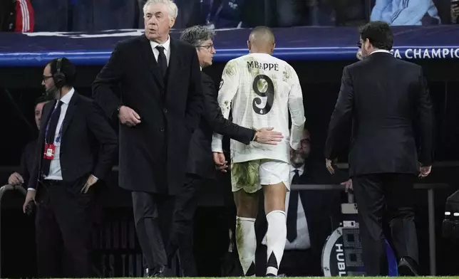 Real Madrid's Kylian Mbappe, center, leaves the field after sustaining an injury during the Champions League quarterfinals second leg soccer match between Real Madrid and Arsenal at the Santiago Bernabeu stadium in Madrid, Wednesday, April 16, 2025. (AP Photo/Bernat Armangue)