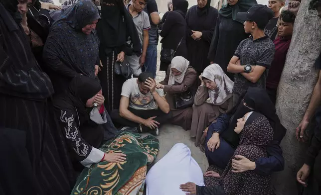 Relatives grieve over the bodies of members of the Jalis and Al-Sharbasi families, killed in an Israeli army airstrike on Yaffa School in Gaza City, Wednesday, April 23, 2025. (AP Photo/Jehad Alshrafi)