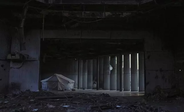 A tent sheltering displaced Palestinians stands in a destroyed hallway inside the Rashad Al-Shawa Cultural Center in Gaza City, Monday, April 21, 2025. (AP Photo/Jehad Alshrafi)