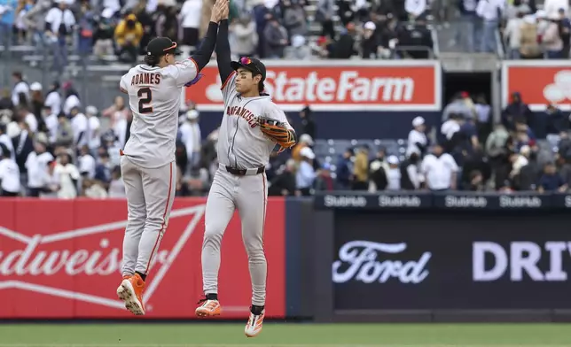 San Francisco Giants' Willy Adames, left, and Jung Hoo Lee, right, react after defeating the New York Yankees during a baseball game Sunday, April 13, 2025, in New York. (AP Photo/Pamela Smith)