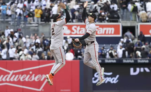 San Francisco Giants' Willy Adames, left, and Mike Yastrzemski, right, react after defeating the New York Yankees during a baseball game Sunday, April 13, 2025, in New York. (AP Photo/Pamela Smith)