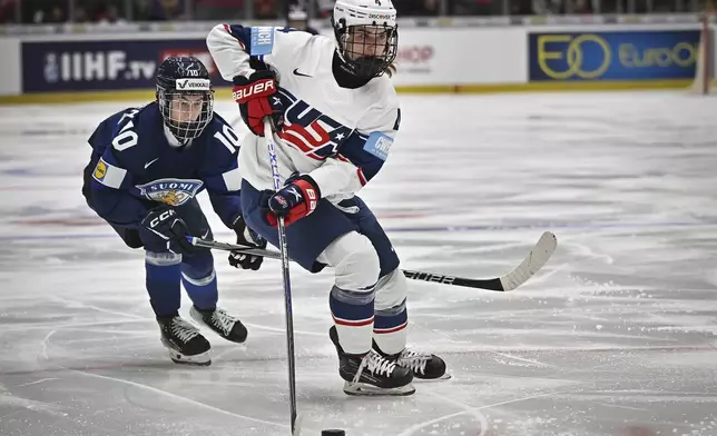 Finland's Elisa Holopainen, rear, chases United States' Caroline Harvey during a Group A match at the women's ice hockey world championships, Wednesday, April 9, 2025, in Ceske Budejovice, Czech Republic. (Lubos Pavlicek/CTK via AP)