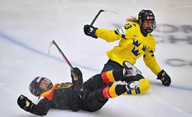 Luisa Welcke, left, of Germany and Thea Johansson of Sweden compete during the IIHF Women's World Championship Group B match Sweden vs Germany, in Ceske Budejovice, Czech Republic, on April 9, 2025.(Pavlicek Lubos/CTK via AP)