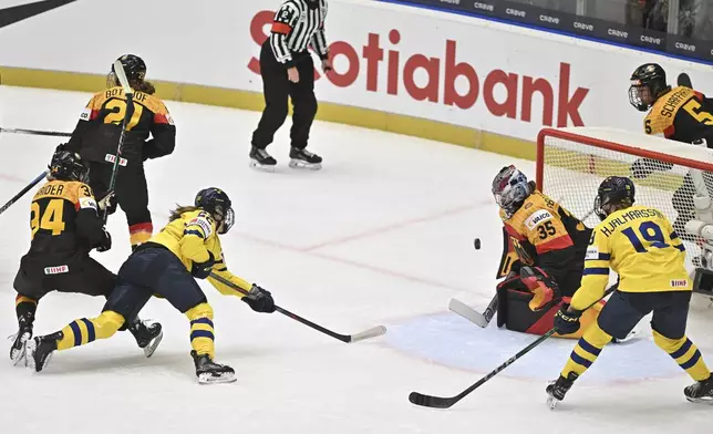 From left, Celina Haider of Germany, Tabea Botthof of Germany, as Hanna Thuvik of Sweden scores against goalkeeper Sandra Abstreiter of Germany and Sara Hjalmarsson of Sweden during the IIHF Women's World Championship, Group B, match between Sweden and Germany, in Ceske Budejovice, Czech Republic, Wednesday, April 9, 2025. (Pavlicek Lubos/CTK via AP)