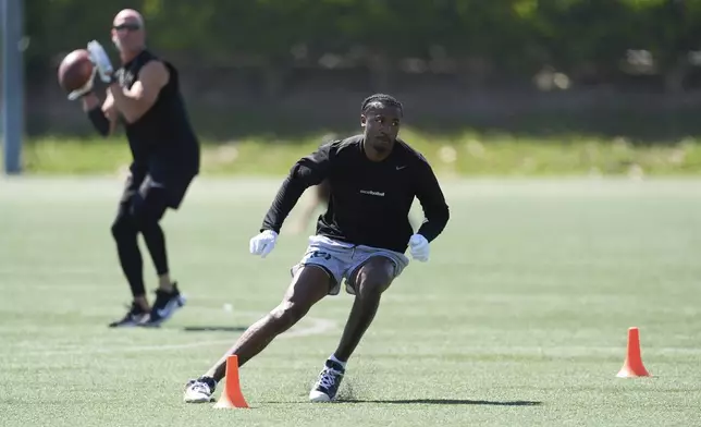 Coach Rick Proehl, left, prepares to throw a pass to wide receiver Tory Horton as Horton trains for the NFL football draft at Lake Forest Sports Park in Lake Forest, Calif., on Friday, March 21, 2025. (AP Photo/Damian Dovarganes)