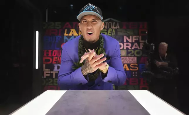 Arizona wide receiver Tetairoa McMillan reacts after putting on a hat after being chosen by the Carolina Panthers with the eighth overall pick during the first round of the NFL football draft, Thursday, April 24, 2025, in Green Bay, Wis. (AP Photo/Jeff Roberson)