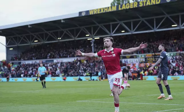 Wrexham's Sam Smith celebrates after scoring his side's third goal during the English League One soccer match between Wrexham and Charlton Athletic at the Racecourse ground in Wrexham, Wales, Saturday, April 26, 2025. (AP Photo/Jon Super)