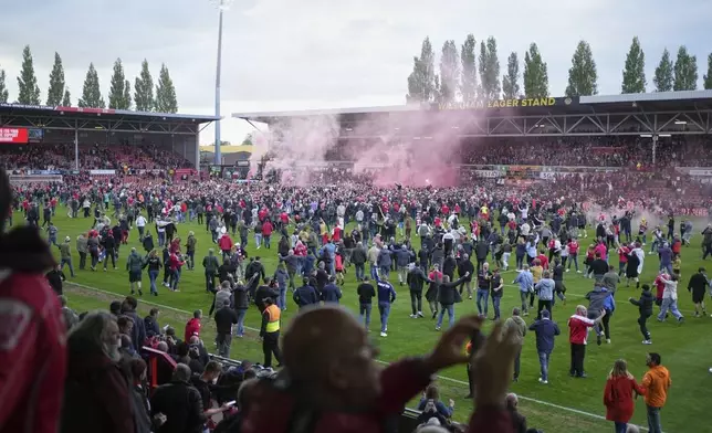 Wrexham fans celebrate after their team won the English League One soccer match between Wrexham and Charlton Athletic at the Racecourse ground in Wrexham, Wales, Saturday, April 26, 2025. (AP Photo/Jon Super)