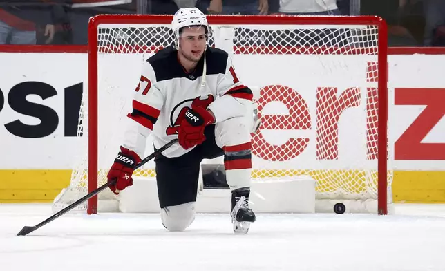 New Jersey Devils' Simon Nemec (17) watches the Carolina Hurricanes celebrate Sebastian Aho's game winning overtime goal during the second overtime period of Game 5 of an NHL hockey Stanley Cup first-round playoff series in Raleigh, N.C., Tuesday, April 29, 2025. (AP Photo/Karl DeBlaker)