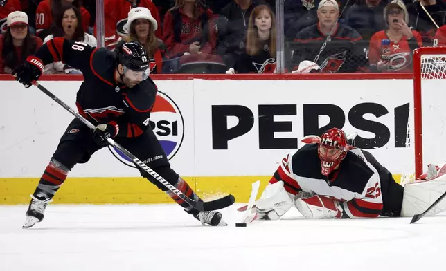 New Jersey Devils goaltender Jacob Markstrom (25) dives to stop the shot of Carolina Hurricanes' Jordan Martinook (48) during the third period of Game 5 of an NHL hockey Stanley Cup first-round playoff series in Raleigh, N.C., Tuesday, April 29, 2025. (AP Photo/Karl DeBlaker)