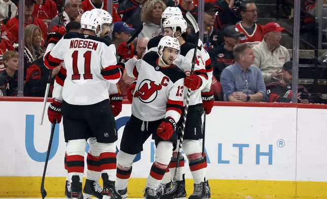 New Jersey Devils' Nico Hischier (13) celebrates his goal against the Carolina Hurricanes during the second period of Game 5 of an NHL hockey Stanley Cup first-round playoff series in Raleigh, N.C., Tuesday, April 29, 2025. (AP Photo/Karl DeBlaker)