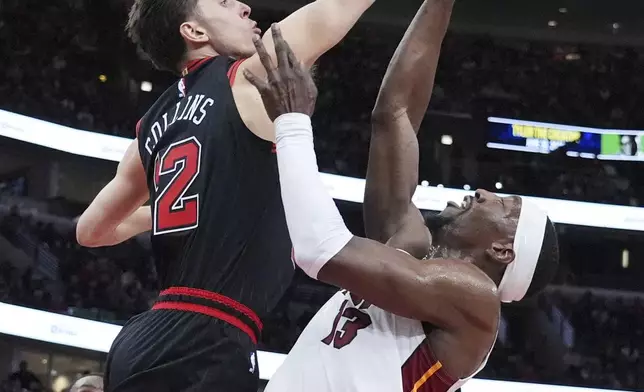 Chicago Bulls forward Zach Collins, left, blocks a shot by Miami Heat center Bam Adebayo during the first half of an NBA play-in tournament basketball game in Chicago, Wednesday, April 16, 2025. (AP Photo/Nam Y. Huh)