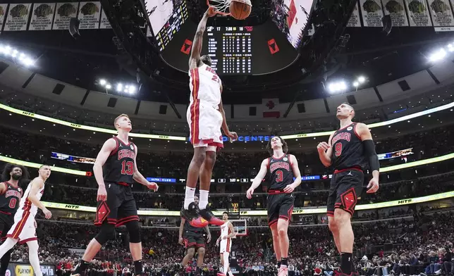 Miami Heat forward Andrew Wiggins, top, dunks against the Chicago Bulls during the first half of an NBA play-in tournament basketball game in Chicago, Wednesday, April 16, 2025. (AP Photo/Nam Y. Huh)