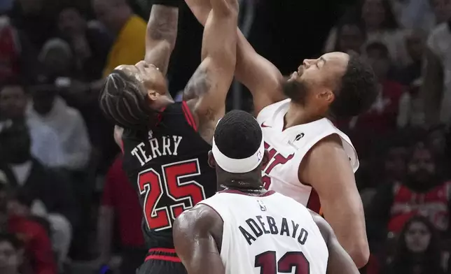 Miami Heat forward Kyle Anderson, right, blocks a shot by Chicago Bulls forward Dalen Terry during the first half of an NBA play-in tournament basketball game in Chicago, Wednesday, April 16, 2025. (AP Photo/Nam Y. Huh)