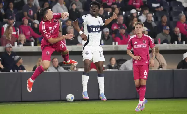 St. Louis City's Kyle Hiebert, left, and Vancouver Whitecaps' Emmanuel Sabbi battle for the ball as St. Louis City's Conrad Wallem (6) watches during the first half of an MLS soccer match Saturday, April 19, 2025, in St. Louis. (AP Photo/Jeff Roberson)