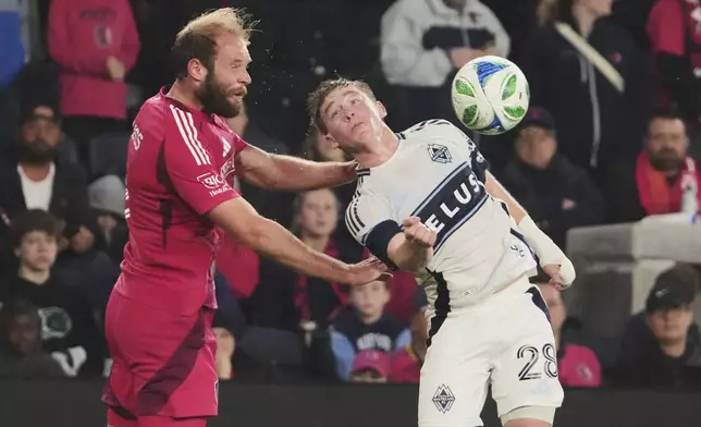 St. Louis City's João Klauss, left, and Vancouver Whitecaps' Tate Johnson battle for the ball during the second half of an MLS soccer match Saturday, April 19, 2025, in St. Louis. (AP Photo/Jeff Roberson)