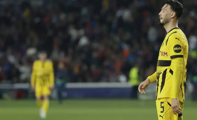 Dortmund's Ramy Bensebaini reacts at the end of the Champions League quarterfinals first leg soccer match between Barcelona and Borussia Dortmund, at the Lluis Companys Olympic stadium in Barcelona, Spain, Wednesday, April 9, 2025. (AP Photo/Joan Monfort)