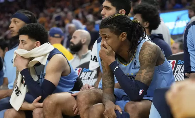 Memphis Grizzlies guard Ja Morant, right, reacts from the bench during the second half of an NBA play-in tournament basketball game against the Golden State Warriors in San Francisco, Tuesday, April 15, 2025. (AP Photo/Jeff Chiu)