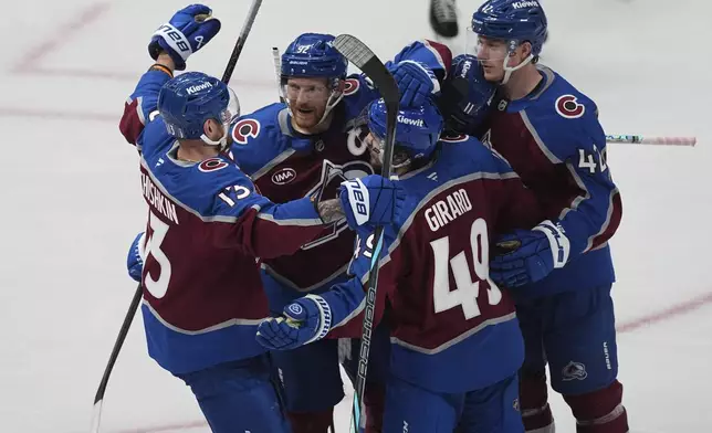 Colorado Avalanche defenseman Samuel Girard (49) is congratulated after scoring a goal by, from left, right wing Valeri Nichushkin, left wing Gabriel Landeskog (92) and defenseman Josh Manson in the third period of Game 4 of an NHL hockey first-round playoff series Saturday, April 26, 2025, in Denver. (AP Photo/David Zalubowski)