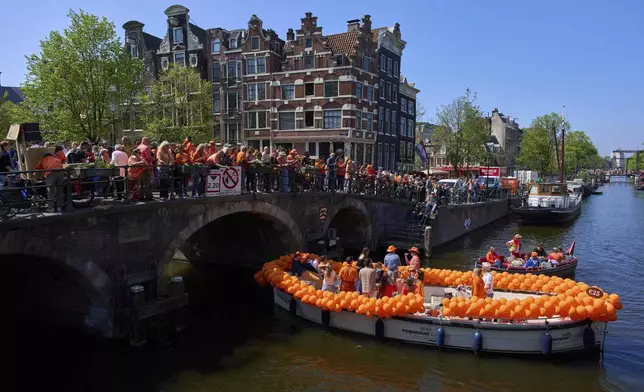 People celebrate King's Day in Amsterdam, Netherlands, Saturday, April 26, 2025. (AP Photo/Peter Dejong)
