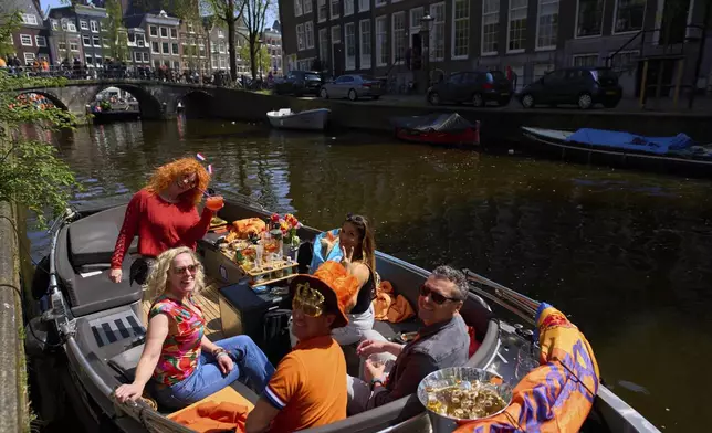 People celebrate King's Day in Amsterdam, Netherlands, Saturday, April 26, 2025. (AP Photo/Peter Dejong)