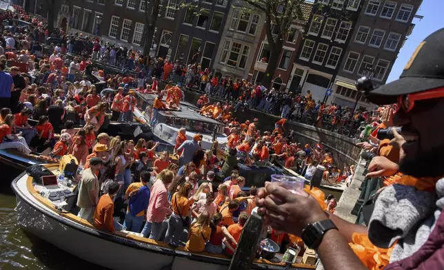 People celebrate King's Day in Amsterdam, Netherlands, Saturday, April 26, 2025. (AP Photo/Peter Dejong)