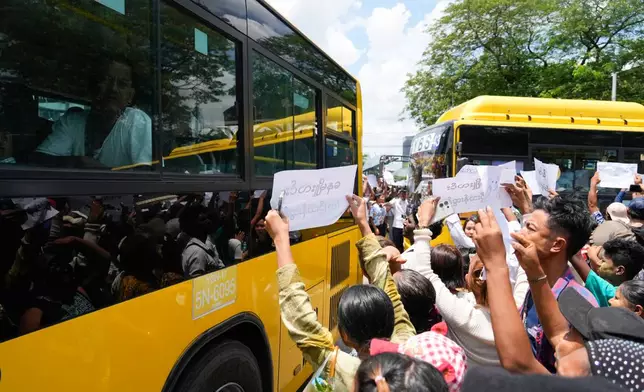 Released prisoners on buses are welcomed by family members and colleagues outside the main gate of Insein prison as the head of Myanmar’s military government granted amnesty to thousands of prisoners to mark the country's traditional New Year Thursday, April 17, 2025, in Yangon, Myanmar. (AP Photo/Thein Zaw)