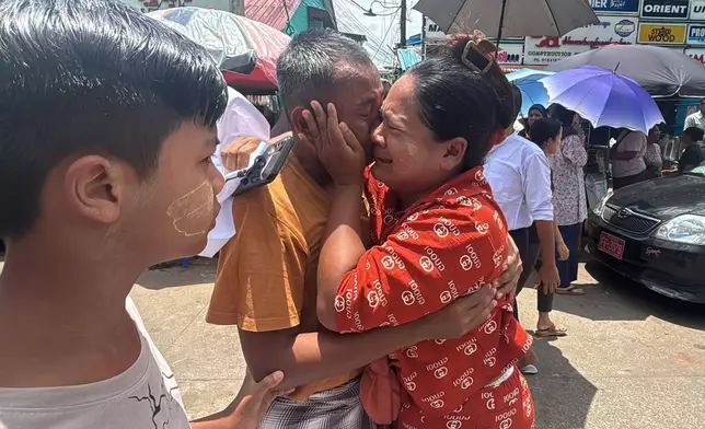 A released prisoner, center, is welcomed by family members outside the main gate of Insein prison as the head of Myanmar’s military government granted amnesty to thousands of prisoners to mark the country's traditional New Year Thursday, April 17, 2025, in Yangon, Myanmar. (AP Photo/Thein Zaw)