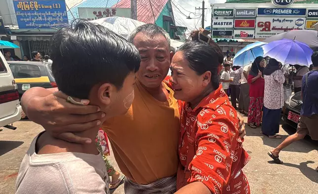A released prisoner, center, is welcomed by family members outside the main gate of Insein prison as the head of Myanmar’s military government granted amnesty to thousands of prisoners to mark the country's traditional New Year Thursday, April 17, 2025, in Yangon, Myanmar. (AP Photo/Thein Zaw)