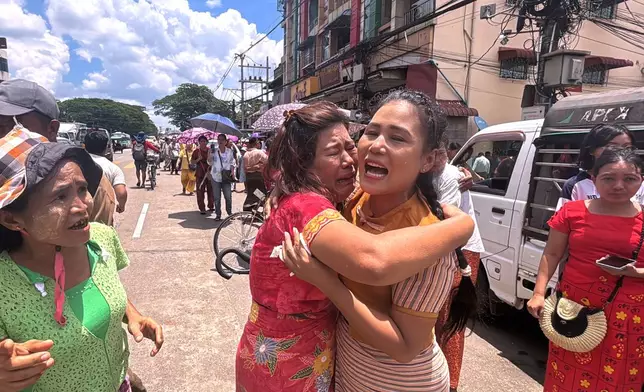 A released prisoner, center right, is welcomed by family members outside the main gate of Insein prison as the head of Myanmar’s military government granted amnesty to thousands of prisoners to mark the country's traditional New Year Thursday, April 17, 2025, in Yangon, Myanmar. (AP Photo/Thein Zaw)