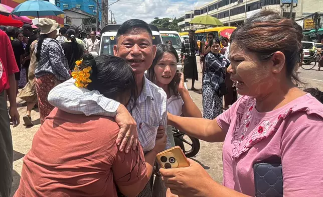 A released prisoner, center, is welcomed by family members outside the main gate of Insein prison as the head of Myanmar’s military government granted amnesty to thousands of prisoners to mark the country's traditional New Year Thursday, April 17, 2025, in Yangon, Myanmar. (AP Photo/Thein Zaw)
