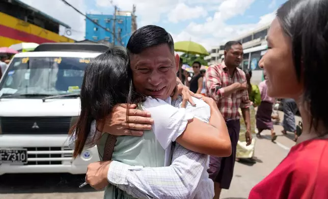 A released prisoner, center, is welcomed by family members outside the main gate of Insein prison as the head of Myanmar’s military government granted amnesty to thousands of prisoners to mark the country's traditional New Year Thursday, April 17, 2025, in Yangon, Myanmar. (AP Photo/Thein Zaw)