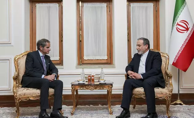 In this photo released by the Iranian Foreign Ministry, Foreign Minister Abbas Araghchi, right, speaks with International Atomic Energy Agency (IAEA) Director General Rafael Mariano Grossi during their meeting in Tehran, Iran, Wednesday, April 16, 2025. (Iranian Foreign Ministry via AP)
