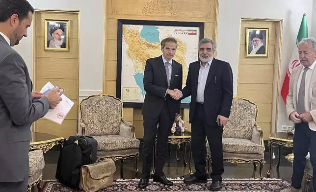In this photo released by the Atomic Energy Organisation of Iran, International Atomic Energy Agency (IAEA) Director General, Rafael Mariano Grossi, left, shakes hands with deputy chief of Atomic Energy Organisation of Iran, Behrouz Kamalvandi, upon his arrival at Mehrabad airport in Tehran, Iran, Wednesday, April 16, 2025. (Atomic Energy Organisation of Iran via AP)