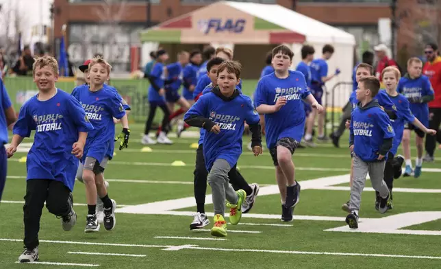 Youth football players and Special Olympics athletes race to the next drill as they take part in the league's annual prospect clinic ahead of the NFL football draft Wednesday, April 23, 2025, in Green Bay, Wis. (AP Photo/Jeff Roberson)